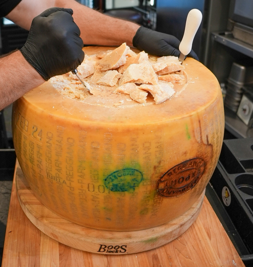 Fresh pasta being finished inside the Parmigiano wheel